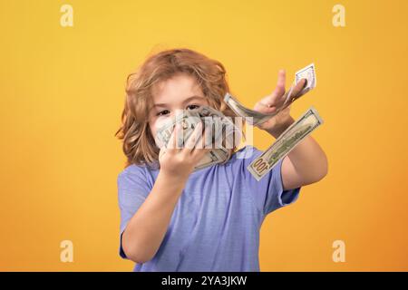 Amerikanische Träume. Der Junge hat viele hundert Dollar isoliert auf gelbem Hintergrund. Stockfoto