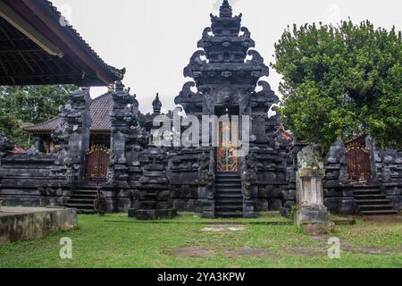 Magischer Sonnenaufgang mit Wolken am Himmel. Dramatischer Himmel am Strand Sanur, Denpasar auf Bali. Tempel im ruhigen Meer am Morgen Stockfoto