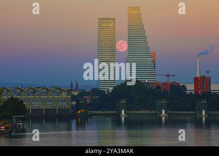 Zwei Wolkenkratzer bei Vollmond und Sonnenuntergang spiegeln sich im ruhigen Wasser, Roche Towers, Hoffmann-la Roche, höchstes Gebäude der Schweiz, Basel, Kanton Stockfoto