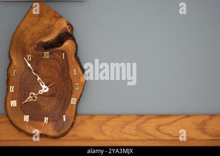 Hölzerne Uhr, handgefertigte Holzwand analoge natürliche Uhr aus Baumstamm mit römischen Ziffern Stockfoto