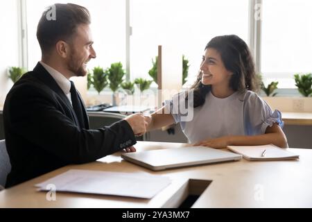 Zwei glückliche junge multiethnische Geschäftspartner geben Handschlag Stockfoto