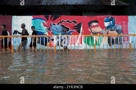 22. August 2024, Feni, Chittagong, Bangladesch: Feni Sadar Upazila ist aufgrund von starken Regenfällen und flussaufwärts liegenden Gewässern überflutet. Menschen laufen in knietiefem Wasser Stockfoto