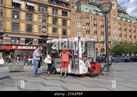 Kopenhagen, Dänemark, 14. Juli 2023: Kunden in einem traditionellen Hot Dog-Wagen auf dem Rathausplatz in Europa Stockfoto