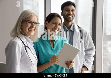 Lächelnde, erfolgreiche Freunde multirassischer Ärzte verwenden digitale Tablets in Teamarbeit Stockfoto