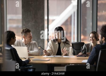 Fröhliche lateinische Teamleiterin, die ein Gruppentreffen abhält Stockfoto