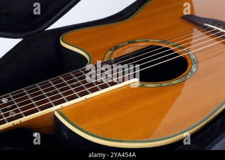 Musikinstrument - Fragment Vintage elektrische Akustikgitarre im Hartschalenkoffer auf weißem Hintergrund. Stockfoto