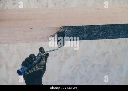 Mann, der einen Holzbalken malt. Selektiver Fokus. Menschen. Stockfoto