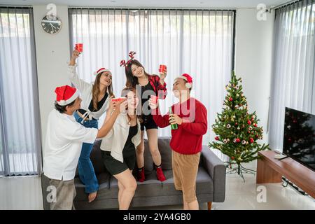 Jungs und Mädchen, die gerne weihnachtsfeiern trinken Stockfoto