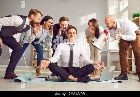 Ruhiger Geschäftsmann, Der Im Büro Unter Lauten Kollegen Meditiert Stockfoto