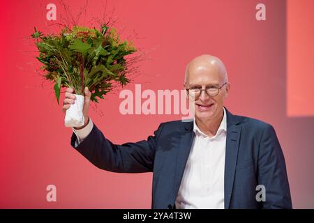 Hamburg, Deutschland. Oktober 2024. Peter Tschentscher (SPD), erster Bürgermeister von Hamburg, steht mit einem Blumenstrauß auf der Bühne während der SPD-Landesvertreterversammlung Hamburg. Tschentscher wurde als Spitzenkandidat für die Hamburger Bundestagswahl gewählt. Quelle: Georg Wendt/dpa/Alamy Live News Stockfoto