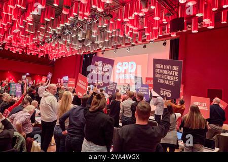 Hamburg, Deutschland. Oktober 2024. Die Teilnehmer applaudieren und halten Banner nach der Rede des Ersten Bürgermeisters von Hamburg Peter Tschentscher (SPD) auf der SPD-Landesvertreterversammlung hoch. Quelle: Georg Wendt/dpa/Alamy Live News Stockfoto