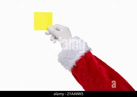 Aufnahme einer Santa Claus Hand, die ein gelbes Notizpapier auf weißem isoliertem Hintergrund hält Stockfoto