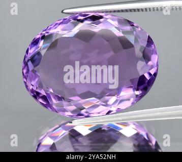 Exquisiter Amethyst-Edelstein im ovalen Schliff mit atemberaubender Klarheit und brillanten Facetten. Stockfoto