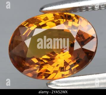 Exquisiter zitriner Edelstein im Oval-Schliff mit brillanten Facetten, die warme goldene Honig-Farbtöne hervorheben. Stockfoto