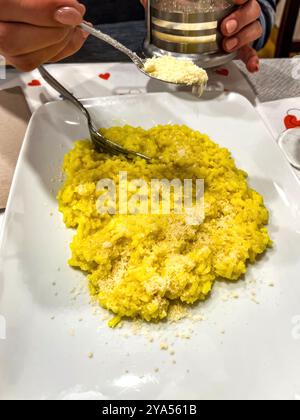 Risotto mit verschiedenen Käsesorten auf einem weißen Teller auf dem Tisch. Hochwertige Fotos Stockfoto