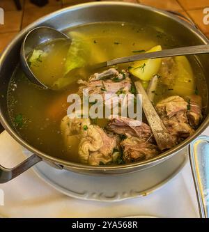 Lammrippsuppe in einem Topf mit Kelle, serviert in einem Restaurant. Hochwertige Fotos Stockfoto