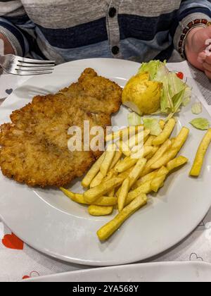 Großes Schweinekotelett mit Pommes frites und Zitrone auf einem Teller. Hochwertige Fotos Stockfoto