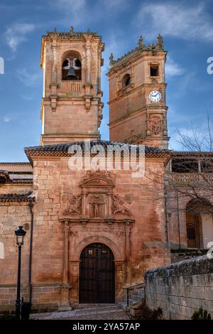 Vertikales Foto der Fassade der Kirche der Santísima Trinidad de Alcaraz, Albacete, Castilla-La Mancha, Spanien, mit dem Glockenturm und der Tard Stockfoto