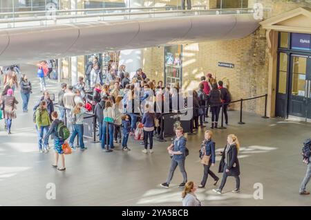 LONDON – MAI 31: Kings Cross Station Wall besuchte Fans von Harry Potter, um Schilder für Bahnsteig neun und drei Viertel mit Trolley zu fotografieren Stockfoto