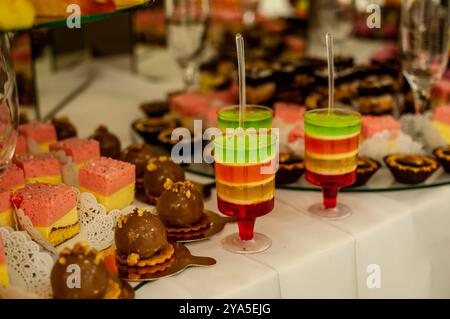 Farbenfroher Desserttisch mit Jello-Lagen und verschiedenen Leckereien. Stockfoto