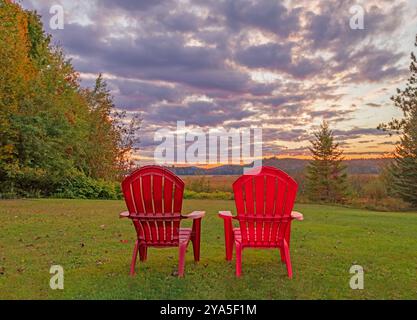 Tupper Lake NY Moody zwei rote Adirondack-Stühle mit Sonnenuntergang aus der Luft Stockfoto