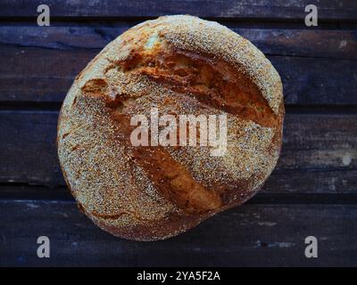 Blick von oben auf rundes Brot. Köstliches frisches Maisbrot mit Streuseln auf einem alten Holztisch. Kopierbereich. Traditionelle Rezepte. Handgemachtes Brot Stockfoto