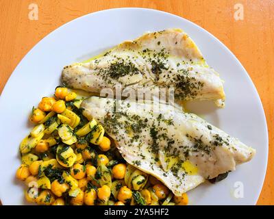 Gegrillte Wolfsbarschfilets mit Kichererbsen, Knoblauch und Petersilie. Stockfoto