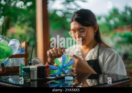 Selektiver Fokus asiatische Frau, die aus Plastikabfällen Handwerk macht Stockfoto