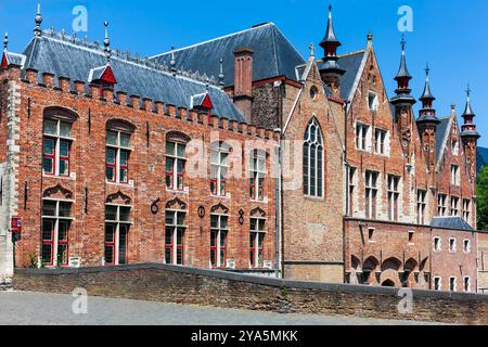 Brügge, Belgien - 11. Juli 2010 : Architektur rund um die Altstadt von Brügge. Rote Backsteingebäude am Fluss Dijver, gegenüber der Blinde-Ezelbrug-Brücke. Stockfoto