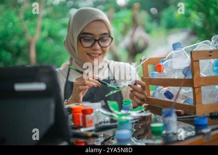 Selektive Focus Hijab-Frau, die recycelten Plastikabfall malt Stockfoto