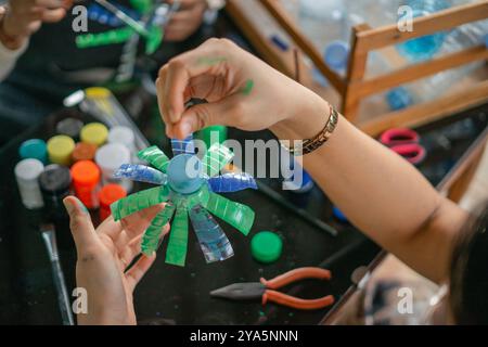 Nahaufnahme einer Frau, die Handarbeit aus Plastikflaschenabfällen hält Stockfoto