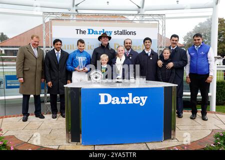 Jockey William Buick, Trainer Charlie Appleby und gewann Verbindungen zu den Trophäen, nachdem er die Darley Dewhurst Stakes mit Shadow of Light beim Dubai Future Champions Day auf der Newmarket Racecourse gewonnen hatte. Bilddatum: Samstag, 12. Oktober 2024. Stockfoto