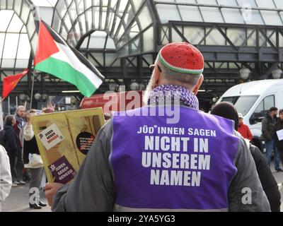 Hamburg, Deutschland. Oktober 2024. Ein Mann mit einer Kippa in den Farben einer Wassermelone und einer lila Weste mit dem Slogan "Juden sagen nicht in unserem Namen" nimmt am Hauptbahnhof an einer Demonstration gegen den Nahostkonflikt Teil. Kredit: Frank Bründel/CitynewsTV/dpa/Alamy Live News Stockfoto