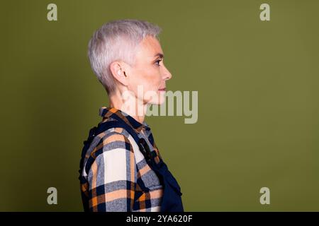 Fotoporträt der attraktiven Reifen Frau professionelles mechanisches Profil gekleidet blaue Arbeitskleidung insgesamt isoliert auf khakifarbenem Hintergrund Stockfoto