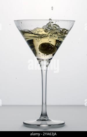 Spritzen Sie in einem Glas trockenen Martini mit grüner Oliven, Alkohol, Cocktail, Bar Stockfoto