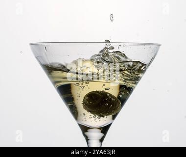 Spritzen Sie in einem Glas trockenen Martini mit grüner Oliven, Alkohol, Cocktail, Bar Stockfoto