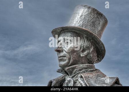 Bronzestatue von Hans Christian Andersen in einem Kopfhut in dramatischer grauer Farbe vor stahlblauem Himmel, Dänemark, 12. Oktober 2024 Stockfoto