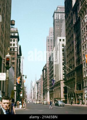 Farbfoto aus der Mitte des 20. Jahrhunderts von einer Manhattan Street in New York City mit Wolkenkratzern im Geschäftsviertel, USA. Stockfoto