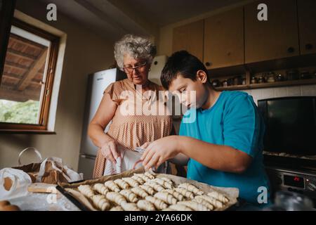 Großmutter und Enkel backen zusammen in der Küche mit leckerem Gebäck Stockfoto