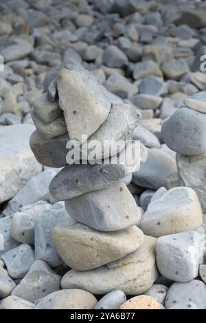 Kieselsteine stapelten sich übereinander an einem felsigen Strand Stockfoto