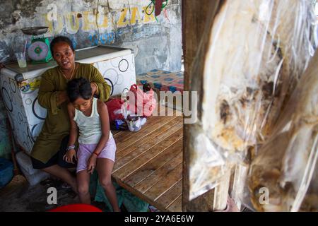 Subang, West-Java, Indonesien. Oktober 2024. YANTI und ihr Kind werden in der Mitte eines Dorfes gesehen, das vom steigenden Meeresspiegel betroffen ist, im Mayangan Village, Subang Regency, West Java. Die Abschürfung an der Nordküste in West-Java ist besonders im Mayangan Village in Subang Regency, einem der am stärksten von Abschürfungen betroffenen Dörfer, stark ausgeprägt. Wird das Dorf nicht sofort verhindert, verschwindet es erodiert vom Meerwasser. Das Gebiet des Dorfes war früher etwa 300 Hektar Land mit 1000 Menschen hier, aber etwa 70 % der Reisfelder, Teiche und Siedlungen sind durch ri verloren gegangen Stockfoto