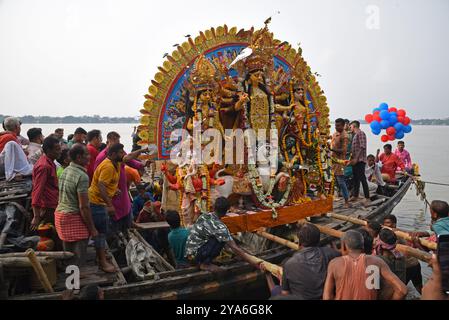 Kalkutta, Indien. Oktober 2024. Gläubige tauchen die Göttin Durga in den Ganges ein, was das Ende des Hindu Durga Puja Festivals markiert. Das Durga Puja Festival ist das größte religiöse Ereignis für die bengalischen Hindus, glauben, dass die Göttin Durga die Macht und den Triumph des Guten über das Böse symbolisiert. Am 12. Oktober 2024 in Kalkutta, Indien. (Foto: Dipa Chakraborty/ Credit: Eyepix Group/Alamy Live News Stockfoto