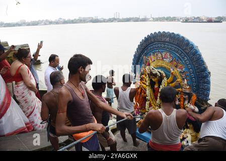 Kalkutta, Indien. Oktober 2024. Gläubige tauchen die Göttin Durga in den Ganges ein, was das Ende des Hindu Durga Puja Festivals markiert. Das Durga Puja Festival ist das größte religiöse Ereignis für die bengalischen Hindus, glauben, dass die Göttin Durga die Macht und den Triumph des Guten über das Böse symbolisiert. Am 12. Oktober 2024 in Kalkutta, Indien. (Foto: Dipa Chakraborty/Eyepix Group/SIPA USA) Credit: SIPA USA/Alamy Live News Stockfoto