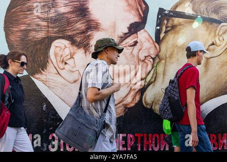 Touristen bei „My God Help me me to Survival this Deadly Love“ (brüderlicher Kuss) Graffiti von Dmitri Vrubel, East Side Gallery, Berliner Mauer, Deutschland Stockfoto