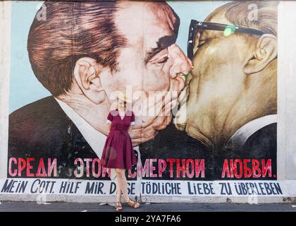 Touristen bei „My God Help me me to Survival this Deadly Love“ (brüderlicher Kuss) Graffiti von Dmitri Vrubel, East Side Gallery, Berliner Mauer, Deutschland Stockfoto