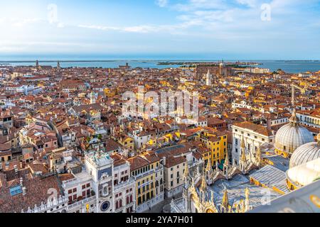 Ein atemberaubender Blick aus der Luft fängt die komplizierten Dächer von Venedig ein und hebt ein Labyrinth aus Kanälen, historischen Gebäuden und lebhaften Farben unter einem klaren blauen Himmel hervor Stockfoto