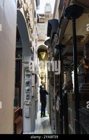 Besucher in einem engen Korridor voller Antiquitäten und Artefakte im John Soane's Museum, London, England Stockfoto