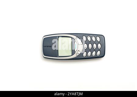 Altes Mobiltelefon mit Drucktaste und grünem Bildschirm auf weißem Hintergrund. Mobiltelefon mit Tasten. Stockfoto