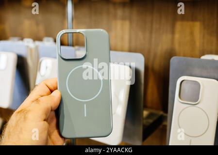 Paris, Frankreich - 20. September 2024: POV einer männlichen Hand, die eine grün-graue Beats Audio-Hülle für das iPhone 16 Pro Max hält, mit Induktionsringen und Magneten zum Aufladen Stockfoto