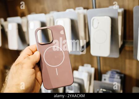 Paris, Frankreich - 20. September 2024: POV einer männlichen Hand, die die neuesten rosafarbenen Apple Computer iPhone 16 durchsichtige Hülle mit MagSafe-Kompatibilität für kabelloses Laden hält Stockfoto